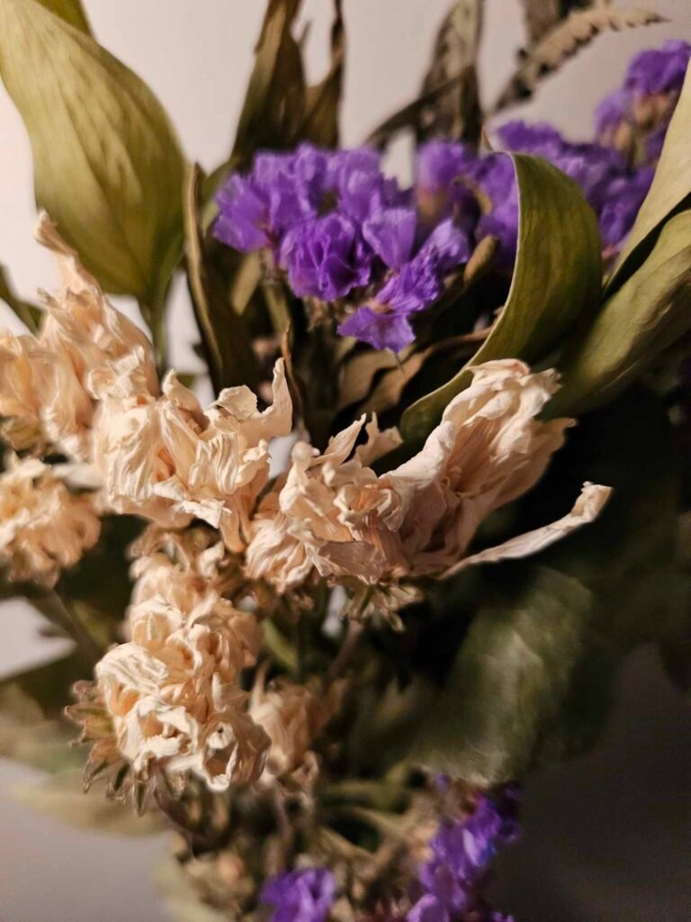 Close up photo of a bouquet of peach and purple flowers — the inspiration for the poem.